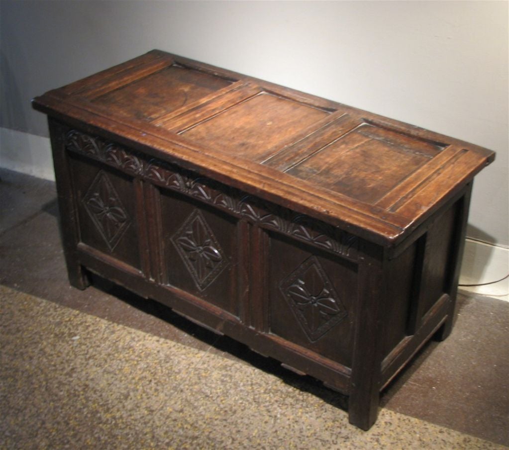 ANTIQUE ENGLISH, LATE 17TH CENTURY OAK COFFER, HAVING A PANELED TOP WITH ORIGINAL PIN HINGES, OVER DIAMOND CARVED PANEL FRONT WITH PANELED SIDES AND BACK<br />
DATING CIRCA 1690