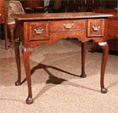 AN ANTIQUE ENGLISH, GEORGE I, OAK LOWBOY WITH A WALNUT CROSSBANDED TOP OVER 3 WALNUT CROSSBANDED DRAWERS STANDING ON 4 WELL DRAWN CABRIOLE LEGS TERMINATING IN PAD FEET

DATING CIRCA 1720