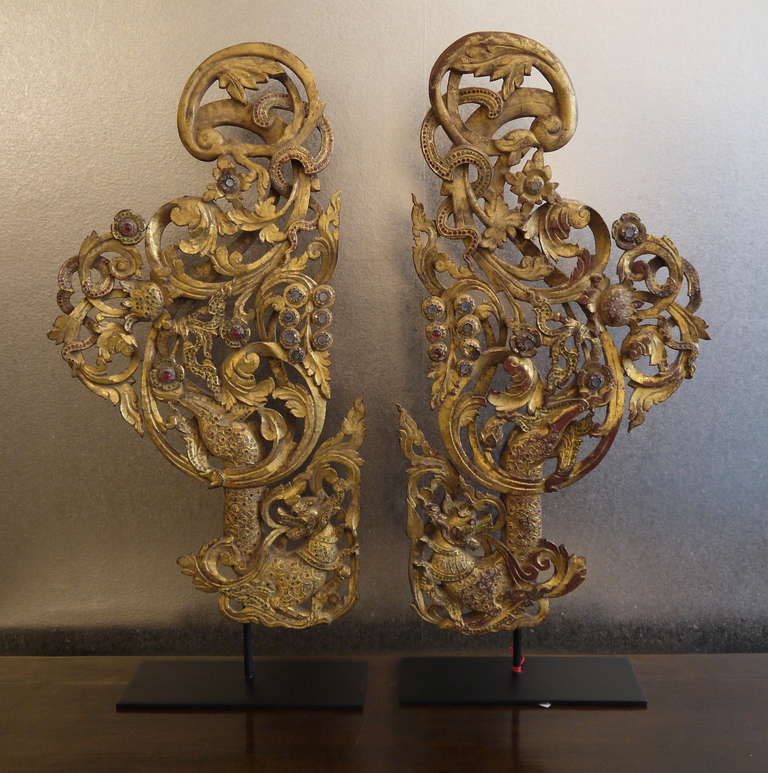 Beautiful pair of carved and gilded architectural elements, with inlaid colored glass and mirror pieced, on stands.