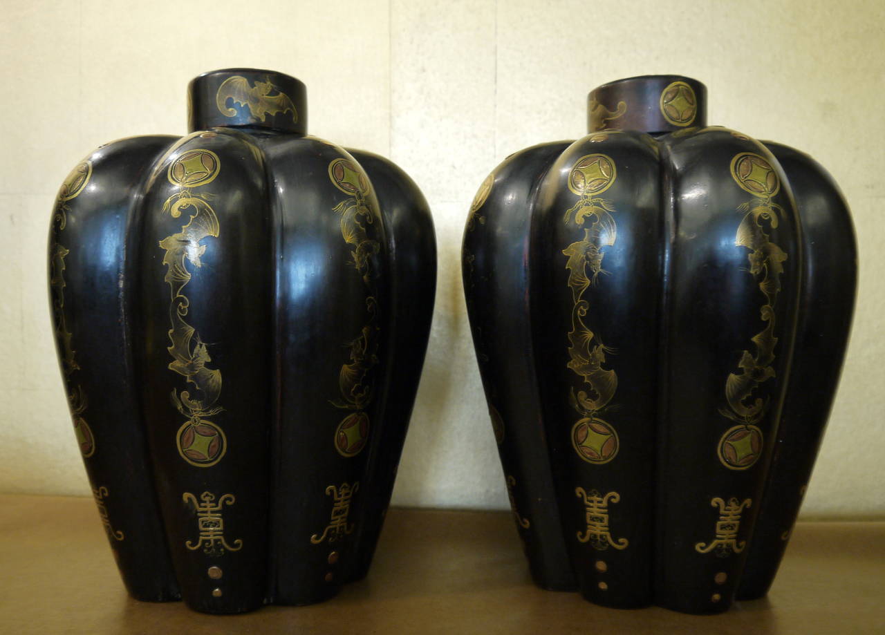 A pair of antique Chinese lacquered vases, hand-painted with auspicious symbols in gilt and color, and lids.