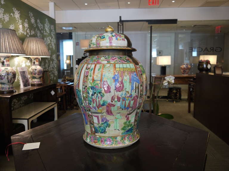 A beautiful and very large early 19th century Famille Rose temple jar, with lid and metal hardware. The design is very finely painted and features landscape and figure design in panels, with intricate borders.