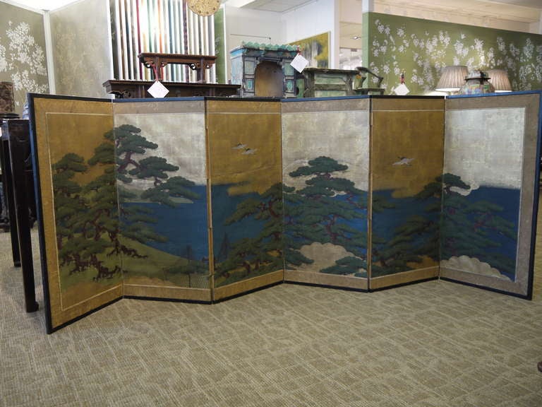 19th century six-panel Japanese screen, with gold leaf background and design of pine trees, a lake and fishing nets.

Surrounded by a traditional fabric brocade border, with a black lacquer frame.