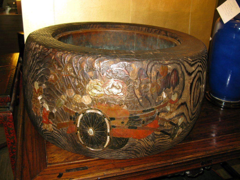 Unusually large antique Japanese hibachi, with copper liner.<br />
<br />
This hibachi is carved from wood (perhaps Kiri), and is inlaid with design of figures and a large flower cart.<br />
<br />
Losses to inlay.