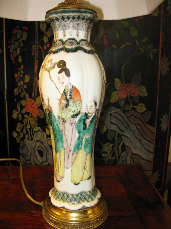 A very nicely painted 19th century vase of unusually graceful shape.  Famille verte design of figures, with interesting, detailed borders at the base and neck.  <br />
<br />
Base drilled, and piece is mounted as a lamp and electrified.<br />
<br