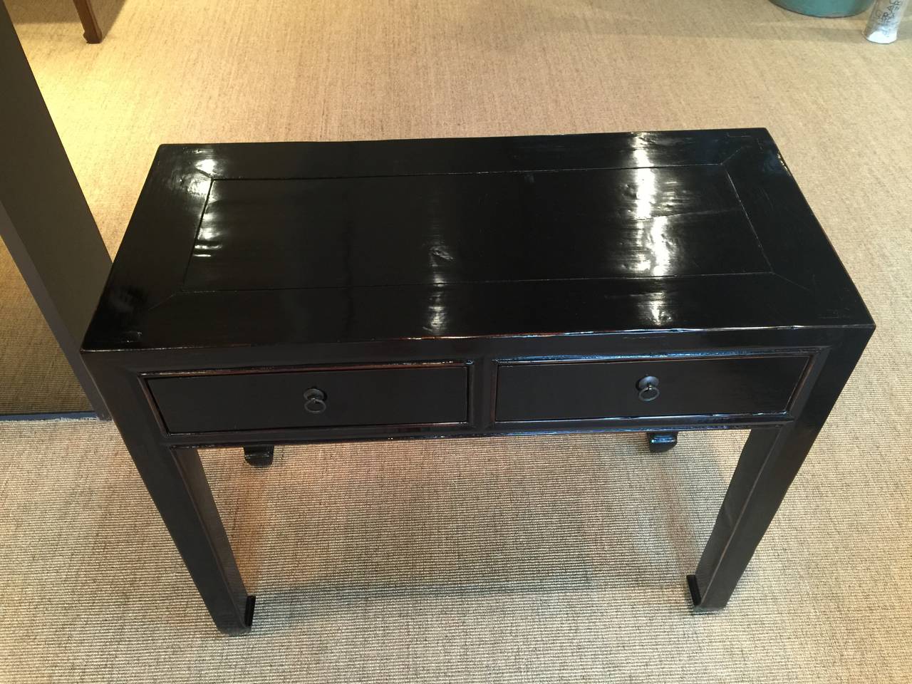 A pair of antique Chinese console tables, with two drawers in each apron. Recently re-lacquered in black.

Pair available. May be purchased individually.