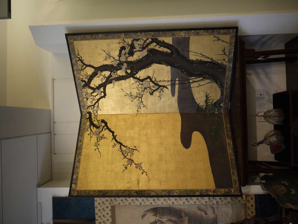 Large scale two panel 19th century Japanese screen with gold leaf background, and design of a flowering cherry tree, with a bird on a branch, bamboo, and a stream.

With traditional fabric brocade border, and wooden frame.