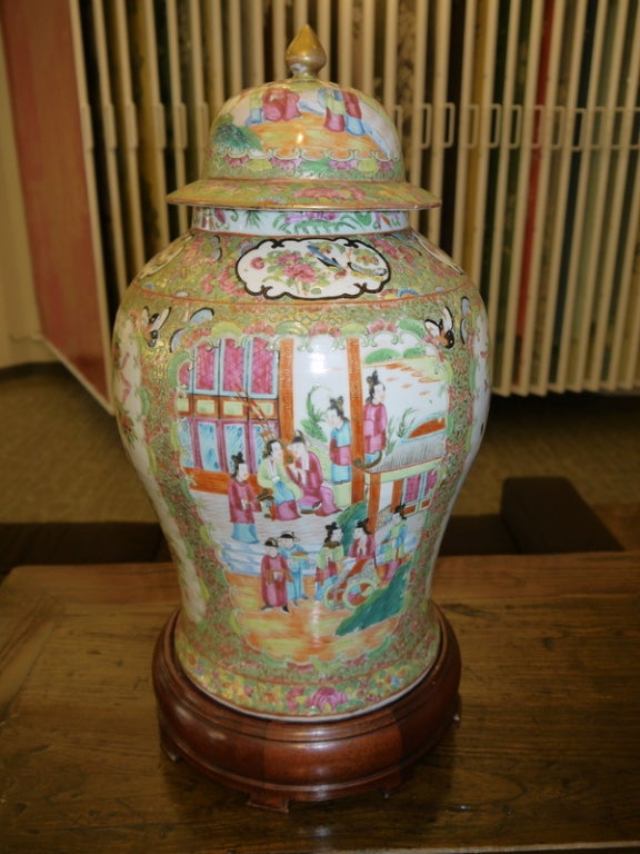 A large pair of 19th century Chinese covered temple jars with gilt decoration, and reserves of birds and butterflies, alternating with figural reserves.

Famille rose tones.

Wood stands included. 

Height without stands is 17