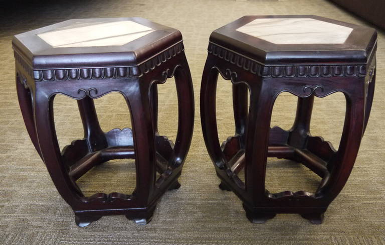 A beautiful pair of hexagonal wood garden stools with marble inserts in tops.