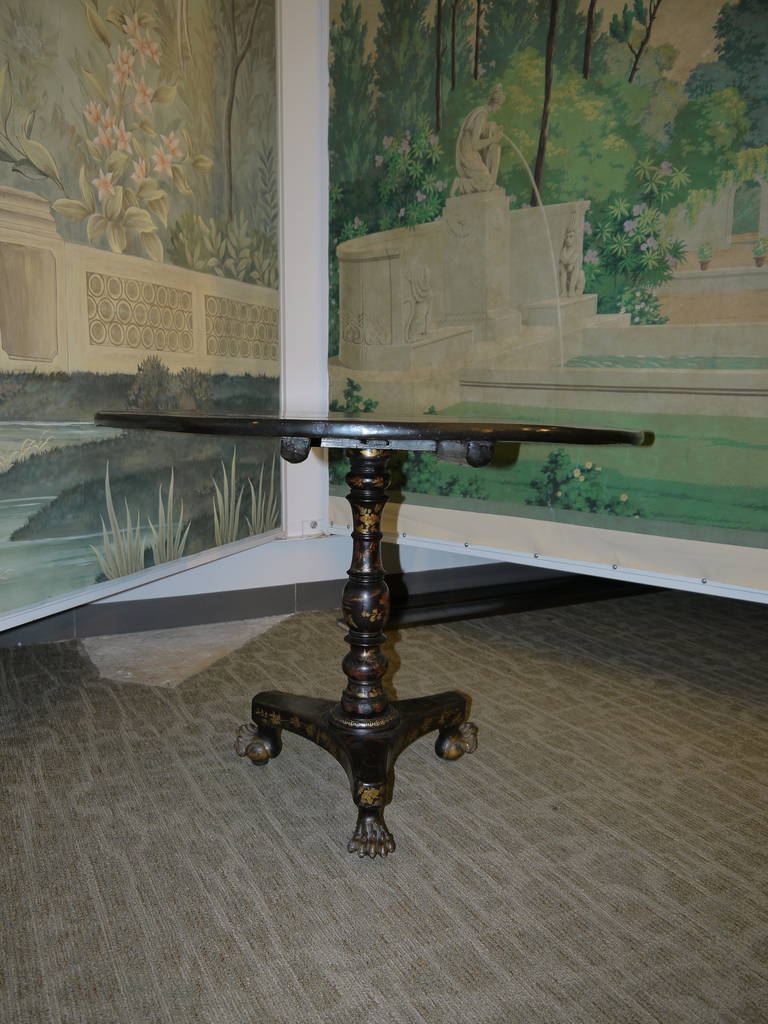 A beautiful black lacquer pedestal table with Chinoiserie landscape design, surrounded by scrolling border in rust and gold tones.

With claw feet.