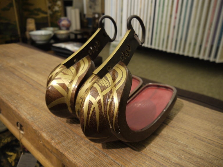 A very decorative pair of Japanese samurai stirrups (Abumi), with red lacquer interior and gold wheat design over brown lacquer.