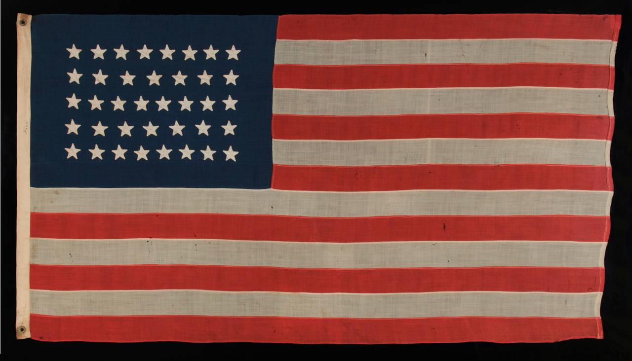 38 HAND-SEWN STARS IN AN UNUSUALLY CONFINED PATTERN OF JUSTIFIED ROWS, ON AN ANTIQUE FLAG IN A RELATIVELY SMALL SCALE FOR THE PERIOD, 1876-1889, COLORADO STATEHOOD:

 38 star American national flag in a bold yet manageable size among its 19th