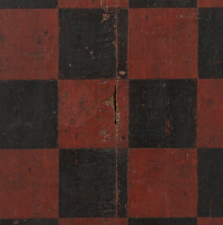 LARGE SCALE, PAINT-DECORATED CHECKERS & DRAUGHTS GAME BOARD IN OXBLOOD RED PAINT, AMERICAN, CA 1840: 

This oversized game board, painted in rich, oxblood red and black, has a large grid for checkers and chess on the front with wisps of attractive