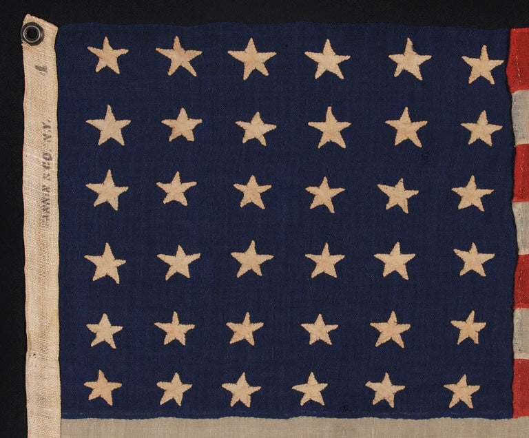 CIVIL WAR ERA, MADE BY ANNIN IN NEW YORK CITY, IN AN UNUSUAL TINY SIZE FOR THE PERIOD AND ENTIRELY HAND-SEWN, NEVADA STATEHOOD, 1864-67:

Entirely hand-sewn American national flag of the Civil War era with 36 stars, in a unusual and desirable