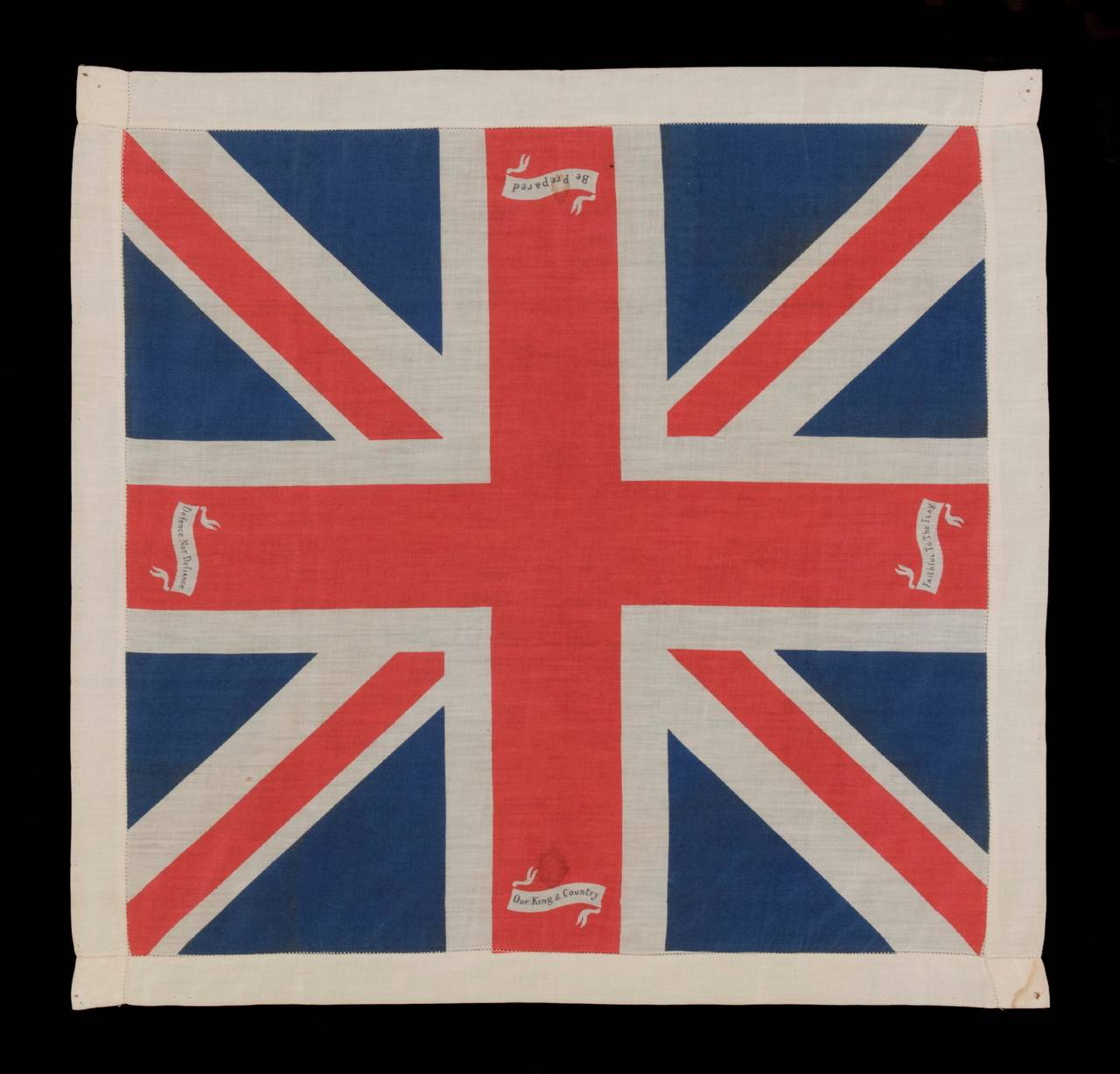 BRITISH UNION JACK KERCHIEF, PRINTED ON SILK, WITH PATRIOTIC SLOGANS, WWI ERA (1914-18):

Printed silk kerchief, in the form of the British Union Jack, decorated with small white scrolls at the base of each arm of the St George's Cross, each of