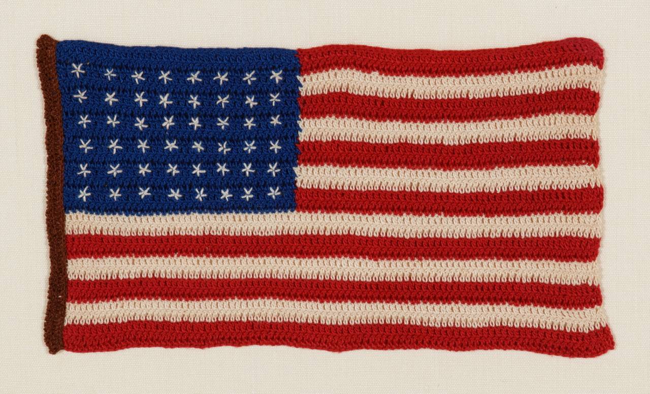 48 stars, crocheted, a particularly beautiful example of the 1912, WWI era, with an attractive chestnut brown hoist:

Beginning around the turn of the century, it became popular to make American flags from various forms of needlework, primarily by