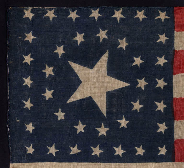 38 STARS IN A RARE CIRCLE-IN-A-SQUARE MEDALLION WITH A HUGE CENTER STAR, ON AN ANTIQUE AMERICAN FLAG MADE FOR THE 1876 CENTENNIAL CELEBRATION BY HORSTMANN BROS. OF PHILADELPHIA

38 star American national flag, press-dyed on wool bunting.  The stars