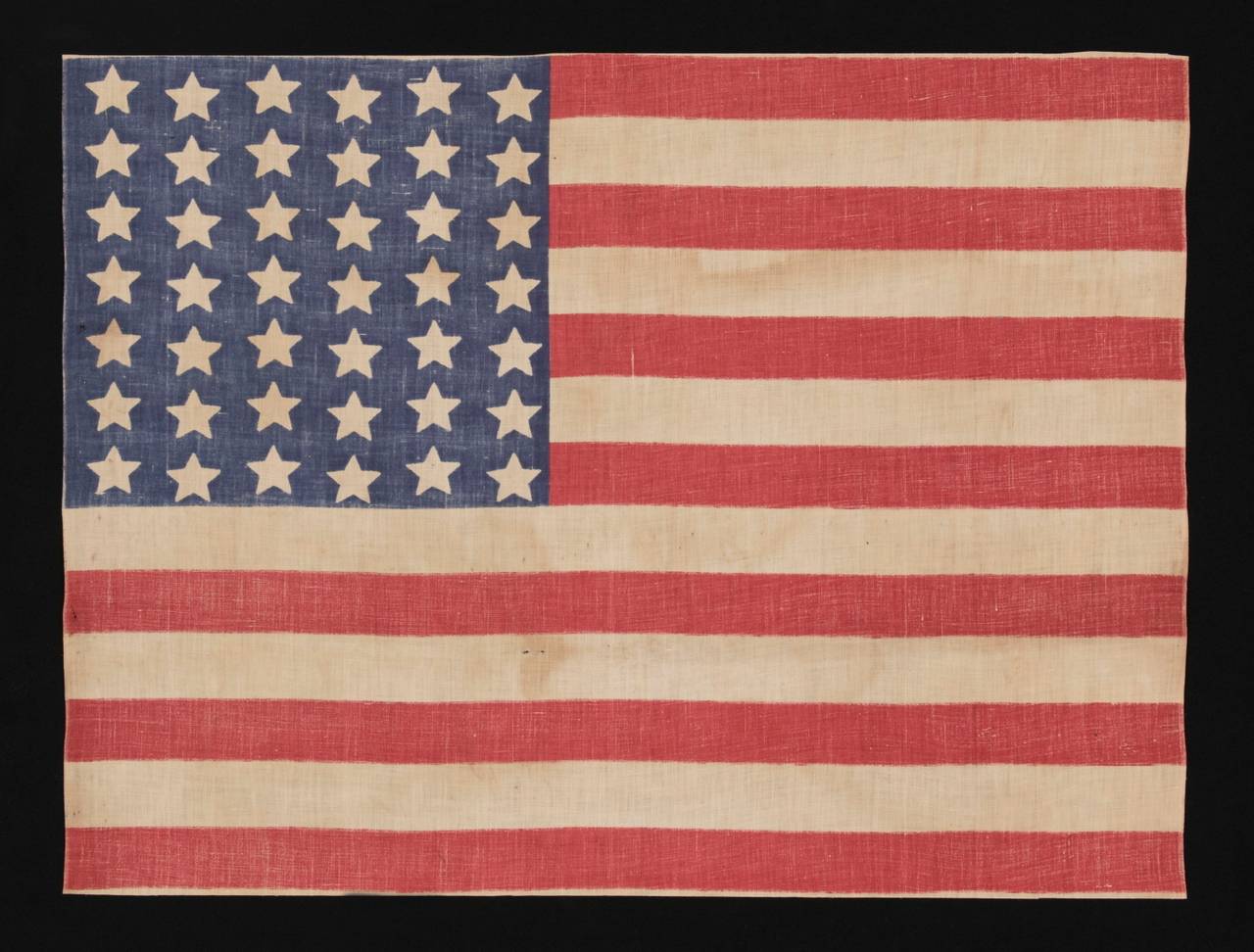 42 STARS IN A WAVE CONFIGURATION OF LINEAL COLUMNS, NEVER AN OFFICIAL STAR COUNT, 1889-1890, WASHINGTON STATEHOOD:

 42 star American parade flag, printed on cotton. This interesting star pattern is called a “wave” configuration. Note how the