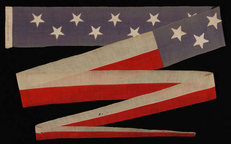 TWENTY-FOOT U.S. NAVY COMMISSIONING PENNANT WITH 13 STARS IN A TWO ROW ARRANGEMENT ON A DUSTY BLUE CANTON, WITH A PRESENTATION INSCRIPTION, 1876 - 1892:

Commissioning pennants are the distinguishing mark of a commissioned U.S. Navy ship. A ship