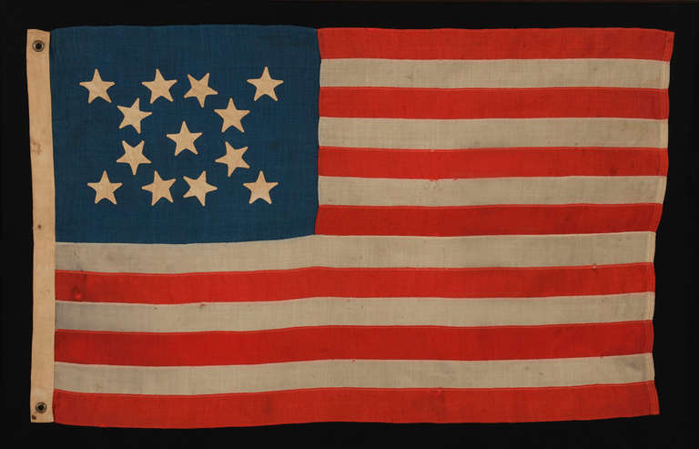13 HAND-SEWN STARS IN A MEDALLION PATTERN ON A SMALL SCALE FLAG OF THE 1876 CENTENNIAL ERA, WITH A PRUSSIAN BLUE CANTON AND AN ATTRACTIVE PRESENTATION:

13 star American national flag, made around the time of the 1876 centennial of American
