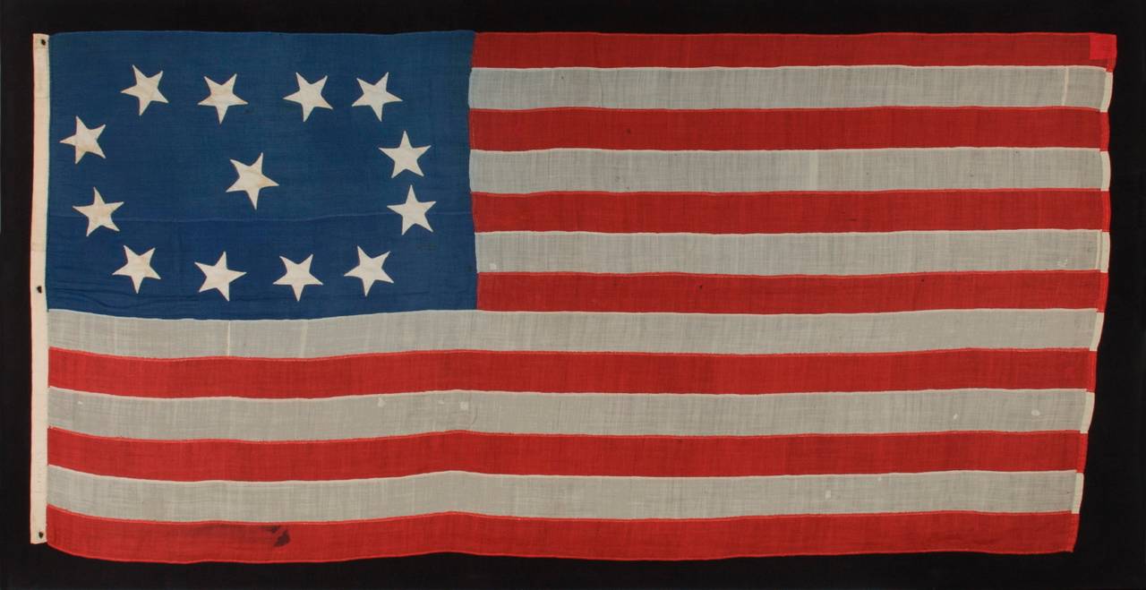 EARLY 13 STAR SHIP'S FLAG WITH AN EXCEPTIONAL, LOPSIDED OVAL VARIATION OF THE 3RD MARYLAND PATTERN, CA 1840-1860, AN ENTIRELY HAND-SEWN EXAMPLE WITH BEAUTIFUL FOLK QUALITIES, ONCE BELONGING TO THE LINSLEY & GAY FAMILIES OF CONNECTICUT AND