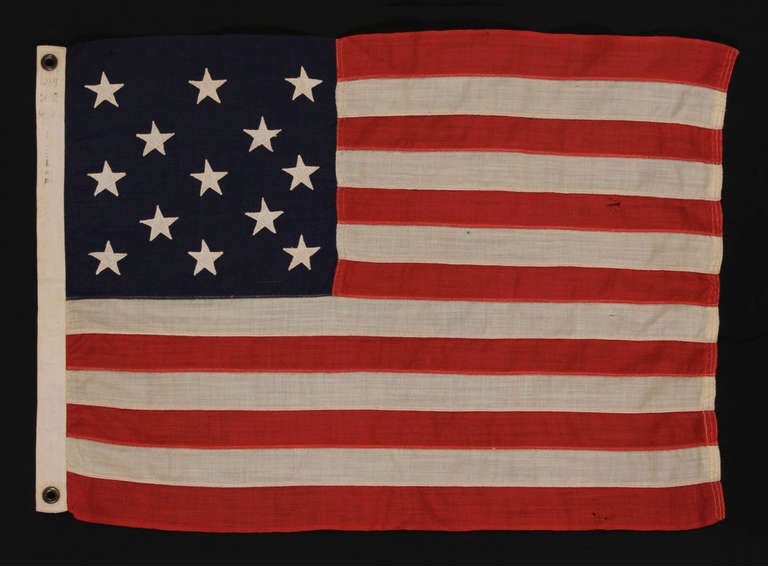 13 STARS ARRANGED IN A 3-2-3-2-3 PATTERN ON A SMALL-SCALE FLAG MADE IN THE 1895-1926 ERA:

13 star flag of the type made from roughly the last decade of the 19th century through the first quarter of the 20th century. The stars are arranged in rows