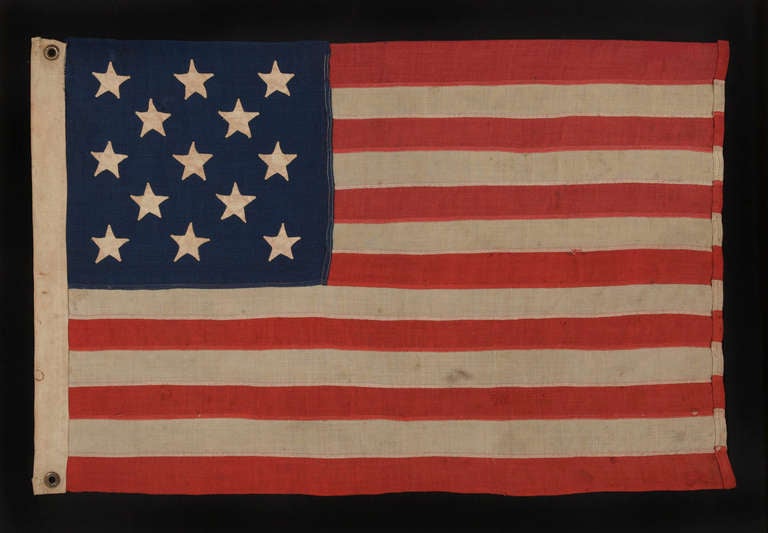 13 HAND-SEWN STARS IN A 3-2-3-2-3 CONFIGURATION, IN AN EXTREMELY SCARCE, SMALL SIZE FOR THE PERIOD, 1876 CENTENNIAL ERA:

 13 Star American national flag, either made in celebration of the nation's centennial of independence in 1876 or perhaps for