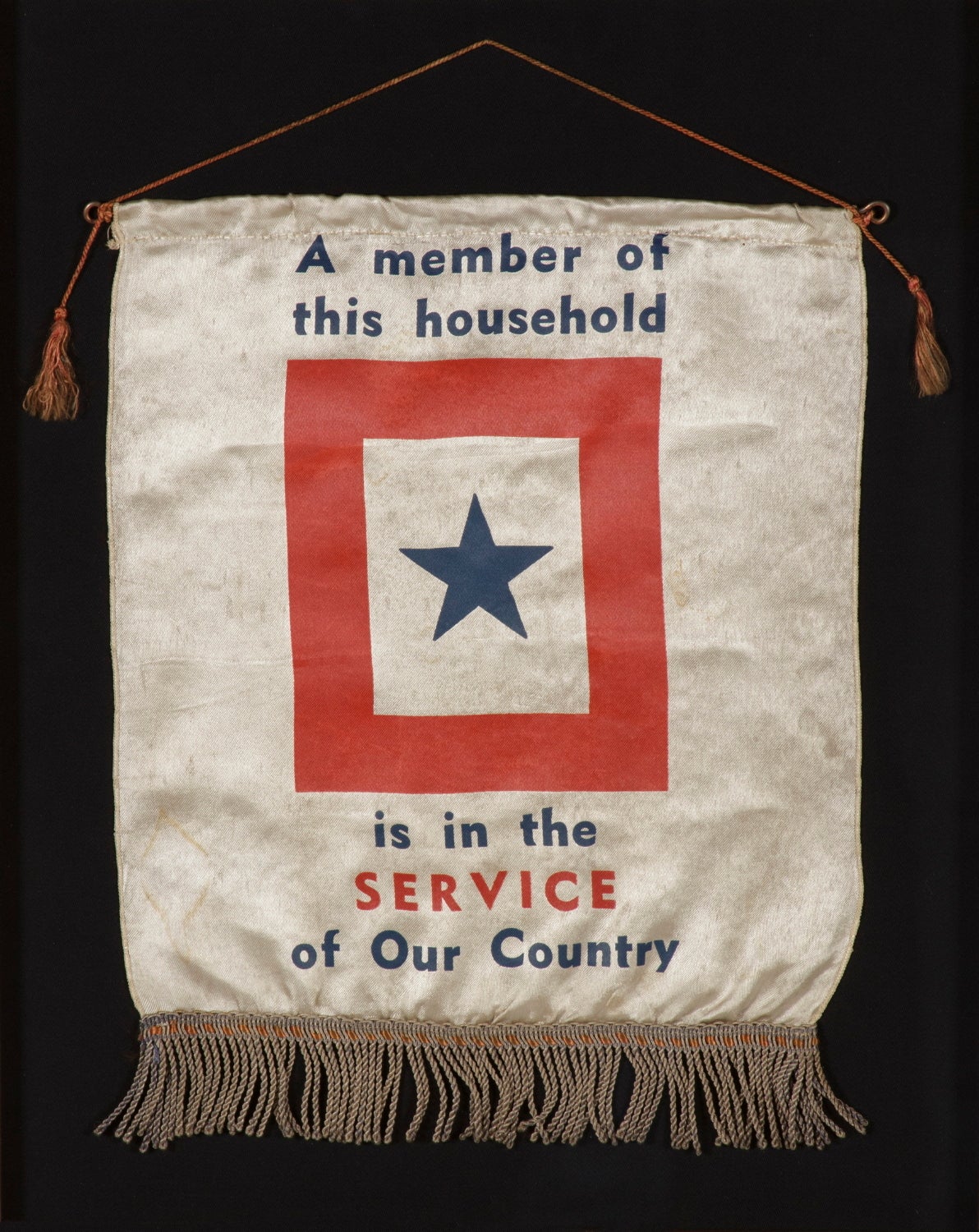 WWII SON-IN-SERVICE BANNER IN A NICE SIZE WITH APPEALING TEXT:

The practice of displaying a son-in-service banner became popular during WWI (U.S. involvement 1917-1918) and was continued or even increased during WWII (U.S. involvement 1941-45).