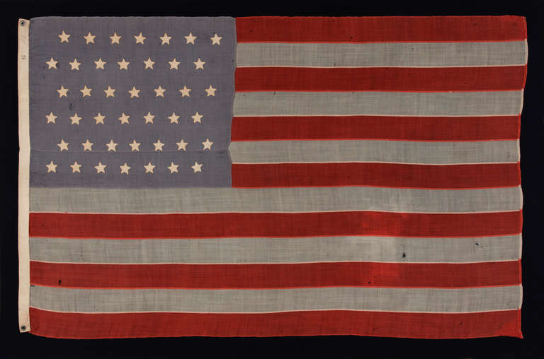 42 HAND-SEWN STARS ON SMALL SCALE FLAG WITH A DUSTY BLUE CANTON, AN UNOFFICIAL STAR COUNT, WASHINGTON STATEHOOD, 1889-1890:

42 star American national flag of the late 19th century, in a very small size for the period, with hand-sewn stars and