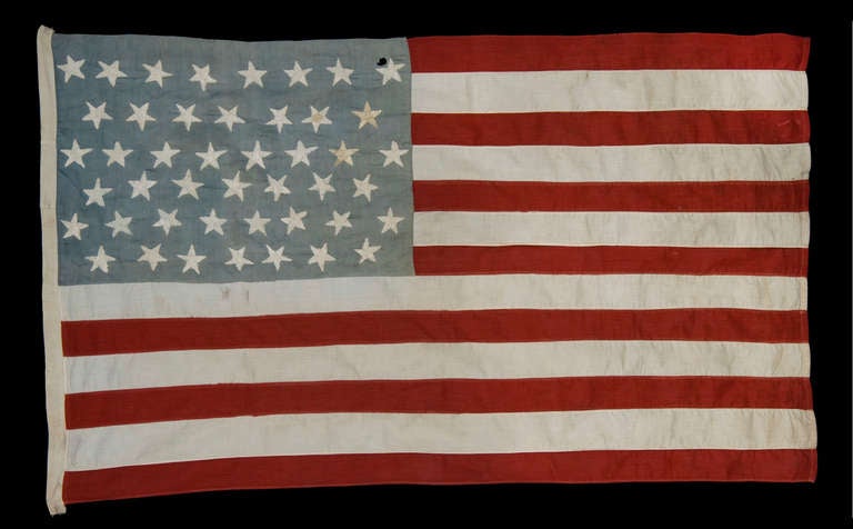 45 Star flag, made in the period between 1896 and 1907. The wonderful, hand-embroidered stars are very unusual in this period, when almost all flag were produced by machine. These are arranged in staggered rows on a canton that has attractively