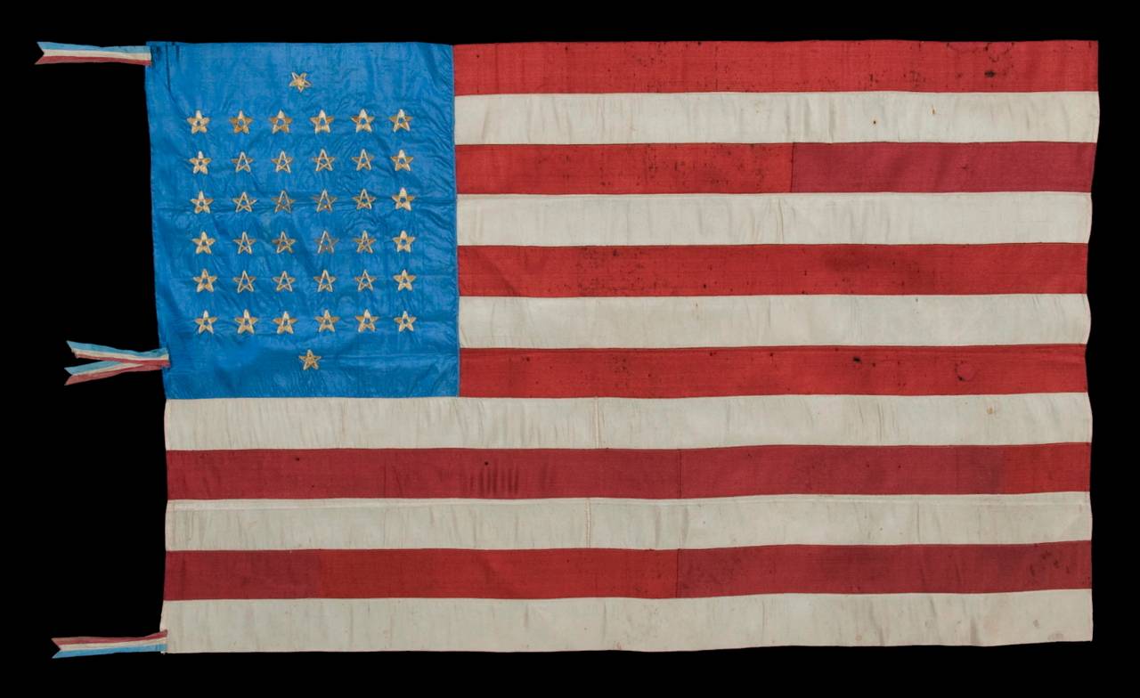38 star, silk flag with 12 stripes and three different styles of hand-embroidered stars, arranged to reflect the number of northern and southern supporting states during the civil war, and resulting in one of the most rare star configurations extant