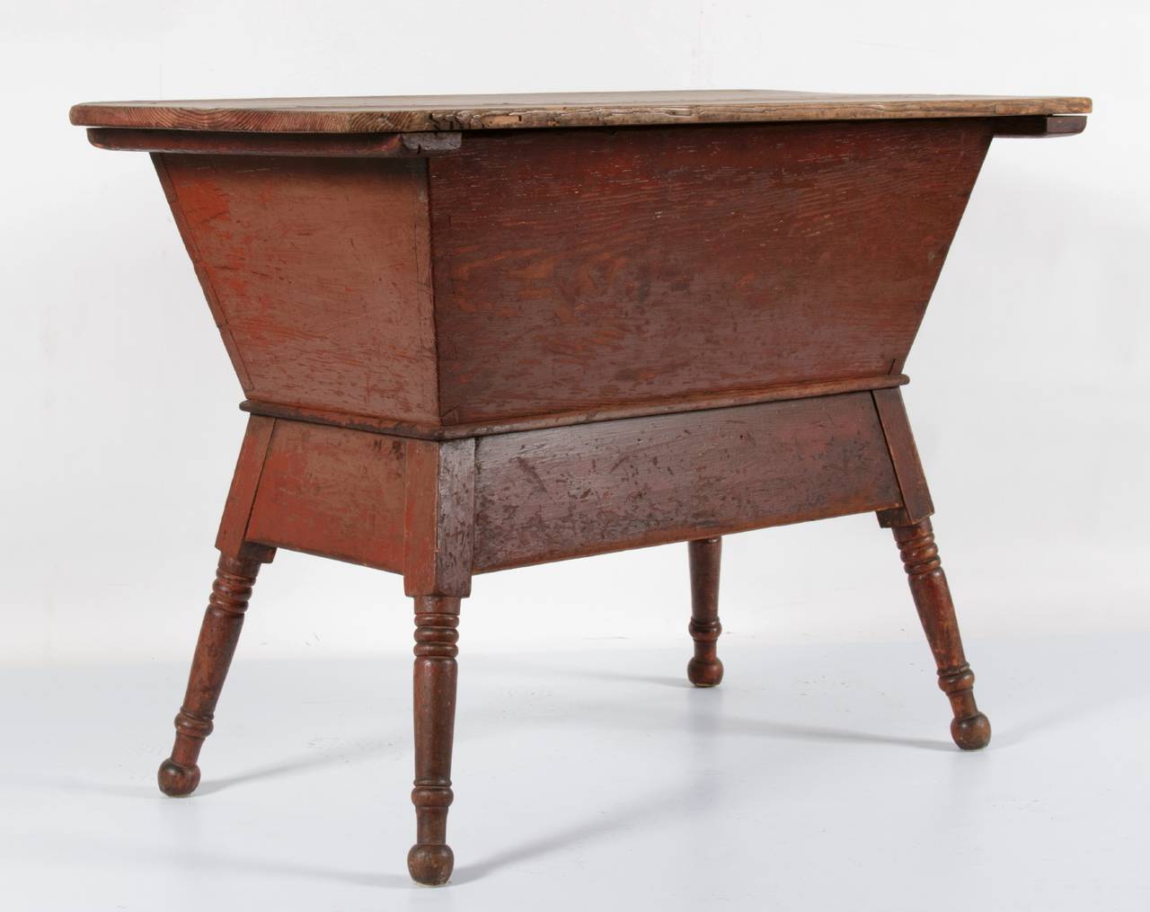 Southern dough table on turned feet in salmon red paint, 1840-1860:

Dough table in an orange/salmon-red painted surface. Made of yellow pine, it's origin is probably Southern. The form is Pennsylvania in style, but the most likely states are