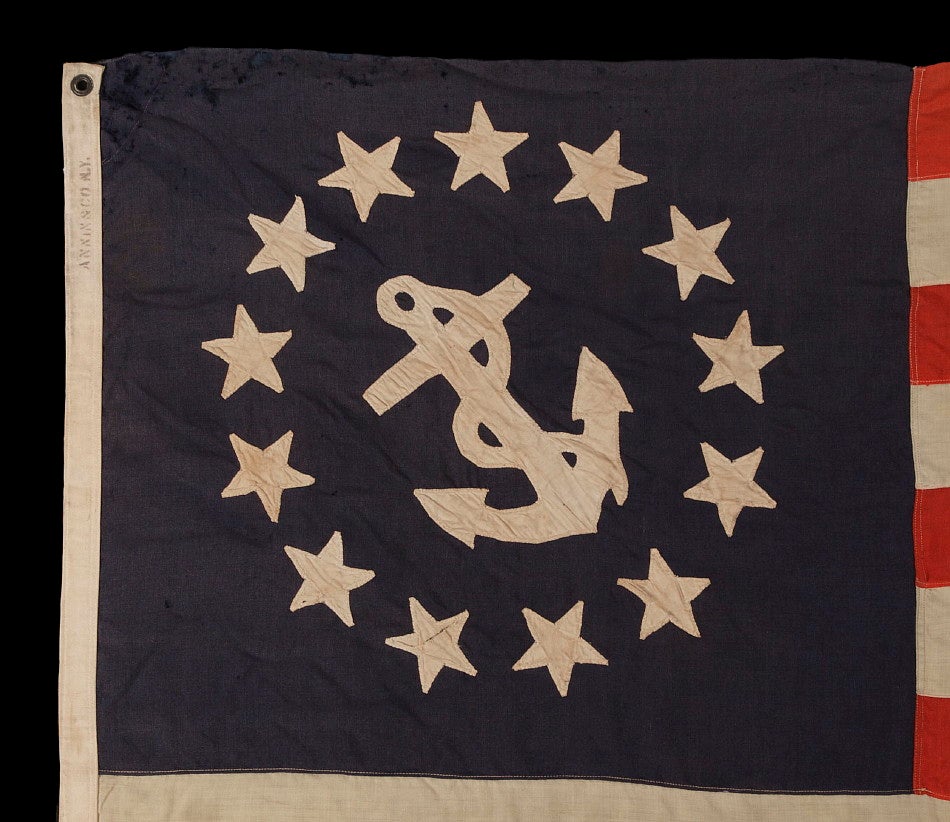 13 STAR PRIVATE YACHT FLAG, A SCARCE AND DESIRABLE EXAMPLE WITH SINGLE-APPLIQUED, HAND-SEWN STARS AND ANCHOR, MADE BY ANNIN IN NEW YORK CITY, CA 1875-1890: 

This private yacht ensign was probably made in the period between the end of the Civil War