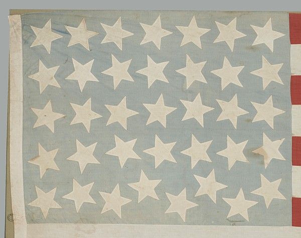 36 STARS, 1864-67, CIVIL WAR ERA, WHIMSICAL STAR PLACEMENT ON A FADED BLUE CANTON:<br />
<br />
36 star American national flag, of the Civil War era, with some great graphic qualities. These include its rather large stars that point in random