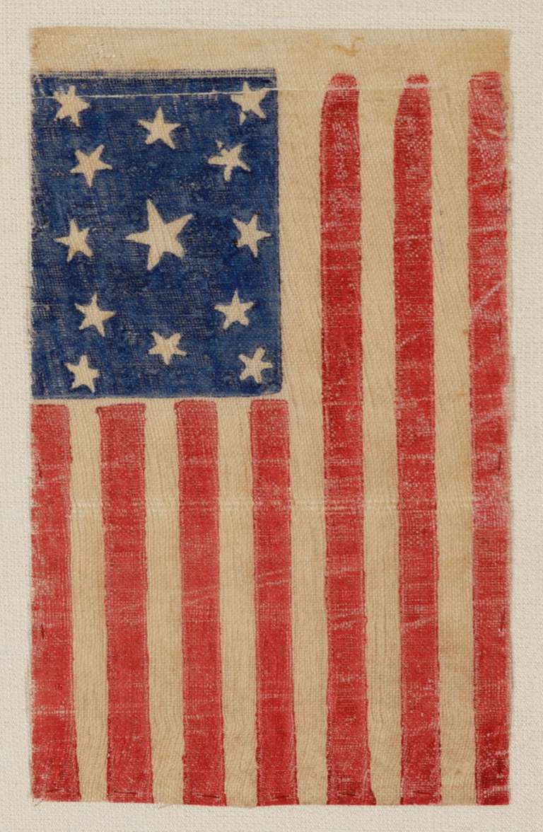 13 star parade flag, printed on coarse, glazed cotton, probably made to commemorate the 100-year anniversary of our nation’s independence in 1876, though possibly as early as the American Civil War (1861-65). The wreath pattern canton, with a large