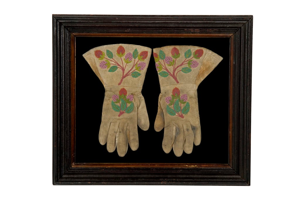 PAIR OF AMERICAN INDIAN BEADWORK GLOVES, CA 1890:<br />
<br />
Native American beadwork, doeskin gloves with pink and red strawberries on green vines. Wonderful graphics, made ca 1890.<br />
<br />
Mounting: The solid walnut molding dates to the