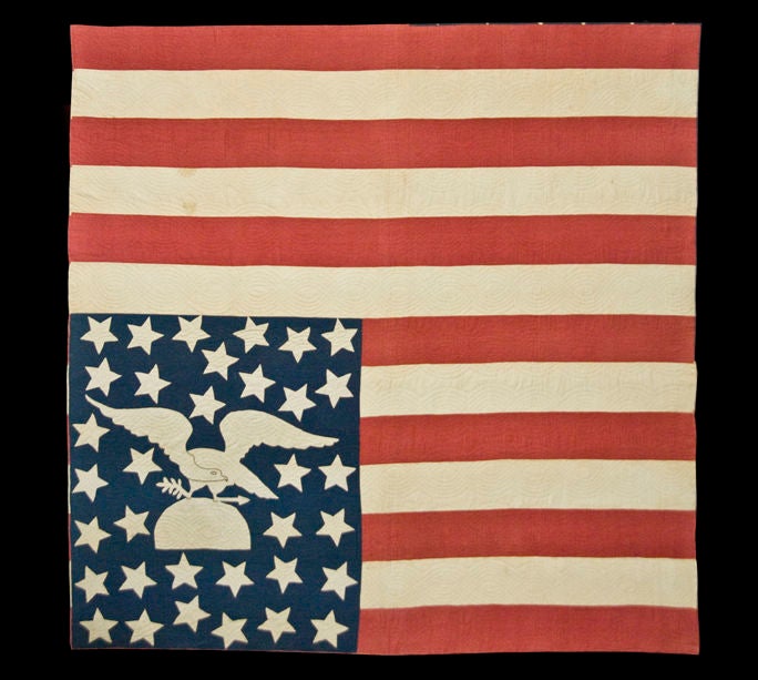 AN AMERICAN FOLK ART MASTERPIECE:  CIVIL WAR PERIOD AMERICAN FLAG QUILT WITH AN EAGLE PERCHED ON A GLOBE AMIDST 34 STARS, 1861-63:<br />
<br />
This exceptional patriotic American flag quilt features a large spread-winged eagle, perched on a