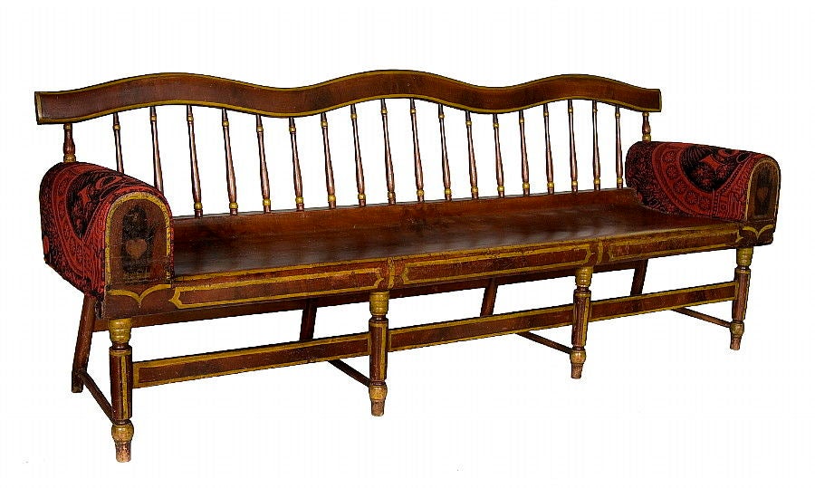 PAINT-DECORATED, PLANK-SEATED SETTEE WITH A UNIQUE, SERPENTINE CREST RAIL AND UPOLSTERED ARMS WITH THE HEART-IN-HAND SYMBOL OF THE ODD FELLOWS FRATERNAL LODGE ON THEIR WOOD PANELED FRONTS, MAINE OR PENNSYLVANIA ORIGIN, 1830-60:

The rise and fall