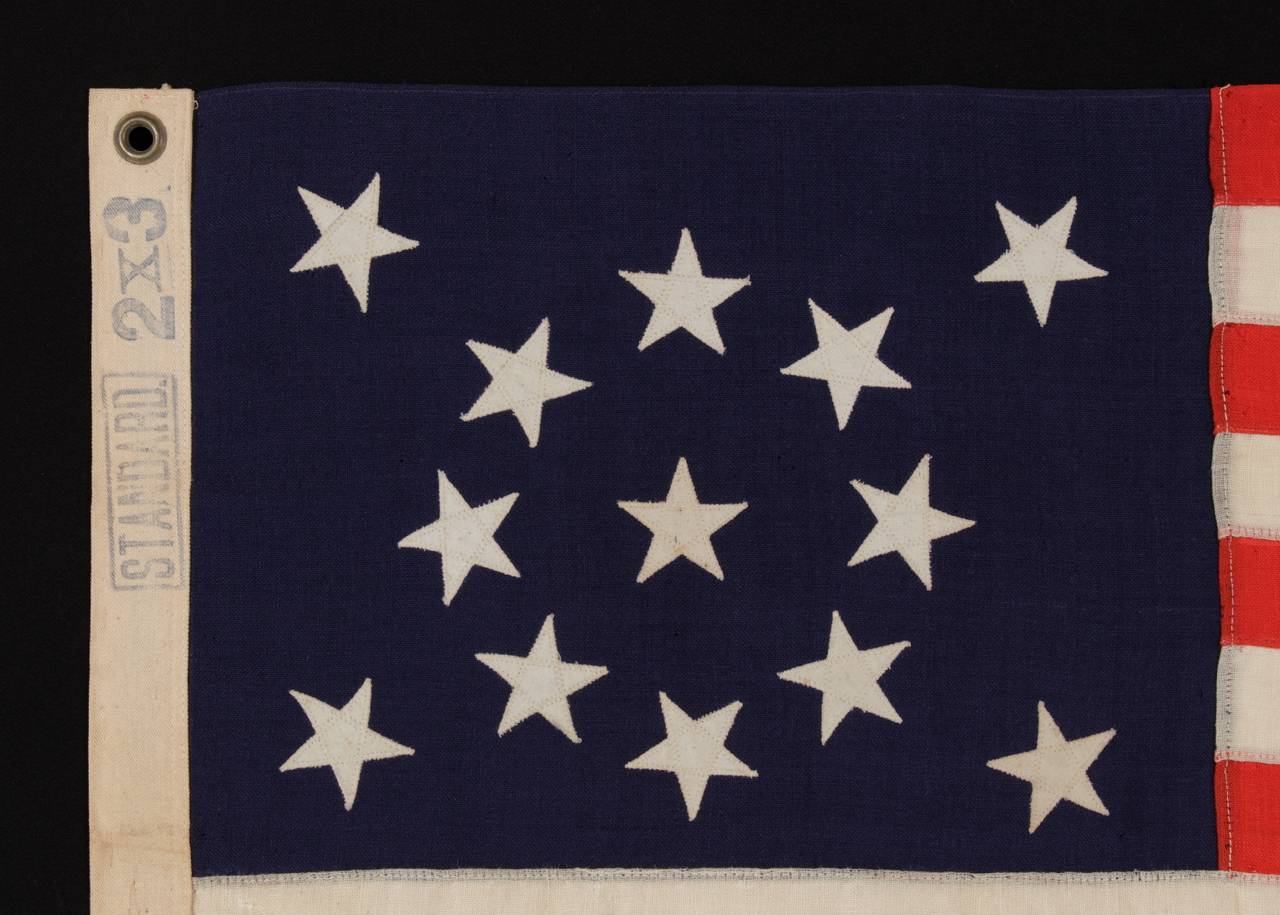 13 STARS ARRANGED IN A MEDALLION PATTERN ON A SMALL-SCALE FLAG OF THE 1895-1926 ERA:

13 star flag of the type made from roughly the last decade of the 19th century through the first quarter of the 20th century. The stars are arranged in a