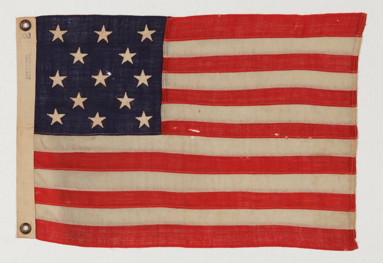 13 stars arranged in A 3-2-3-2-3 lineal configuration on an tiny antique American flag among its counterparts with pieced-and-sewn construction, circa 1895-1920s, made by Annin In New York City:

 This 13 star antique American flag is of the type