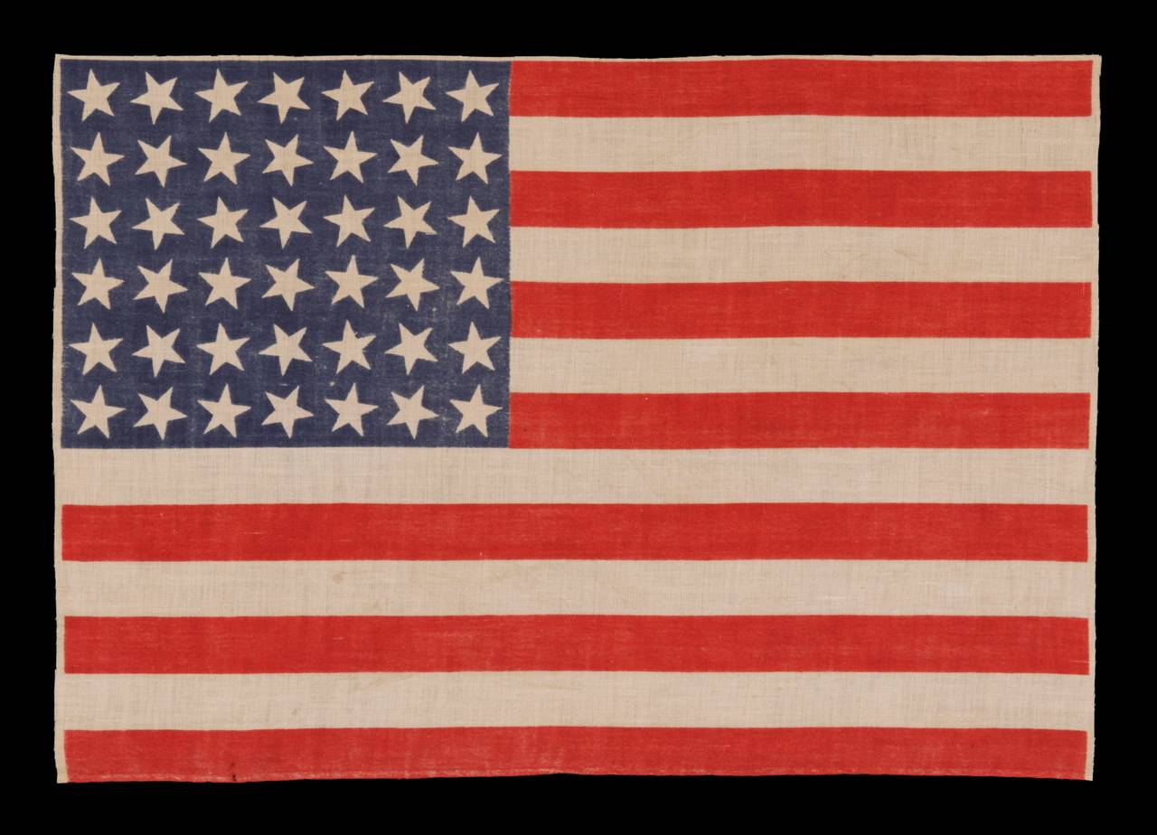 42 STARS, 1889-1890, AN UNOFFICIAL STAR COUNT, WASHINGTON STATEHOOD, SCATTERED STAR POSITIONING:

42 star parade flag, printed on cotton muslin. The stars are arranged in a rectilinear fashion, but vary in position on their vertical axis. This