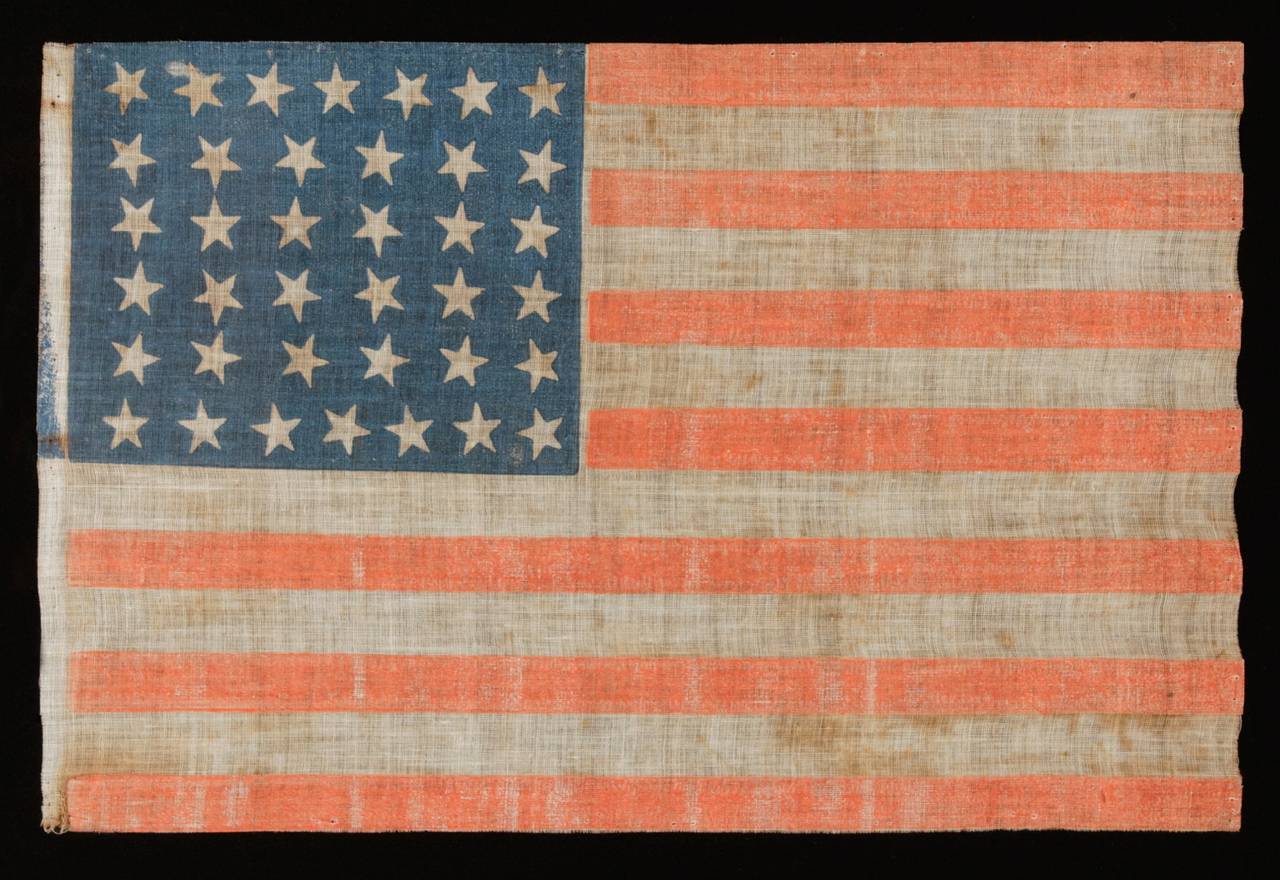 38 STARS WITH SCATTERED POSITIONING, COLORADO STATEHOOD, 1876-1889:

 38 star American national parade flag, printed on coarse, glazed cotton. Note how the stars are arranged in justified rows of 7-6-6-6-6-7 and are oriented in a variety of