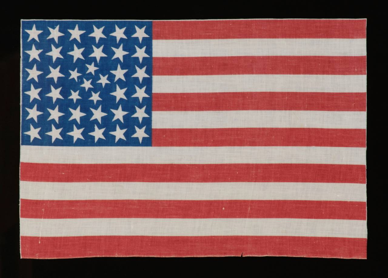38 STARS IN AN EXTREMELY RARE PATTERN THAT BEARS A CLUSTER OF 6 SMALL STARS WITHIN A LINEAL PATTERN OF LARGER STARS, 1876-1889, COLORADO STATEHOOD:

38 star American national parade flag, printed on cotton. This is an extremely rare example of a