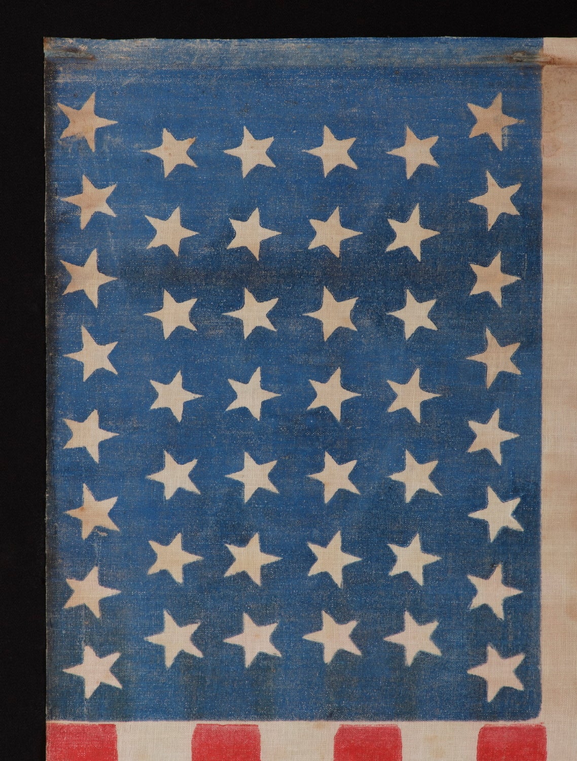 44 DANCING OR TUMBLING STARS IN AN HOURGLASS FORMATION, WYOMING STATEHOOD, 1890-1896:

44 star American parade flag printed on coarse, glazed cotton. These are configured in rows of 8-7-7-7-7-8, with the top and bottom rows offset so that they