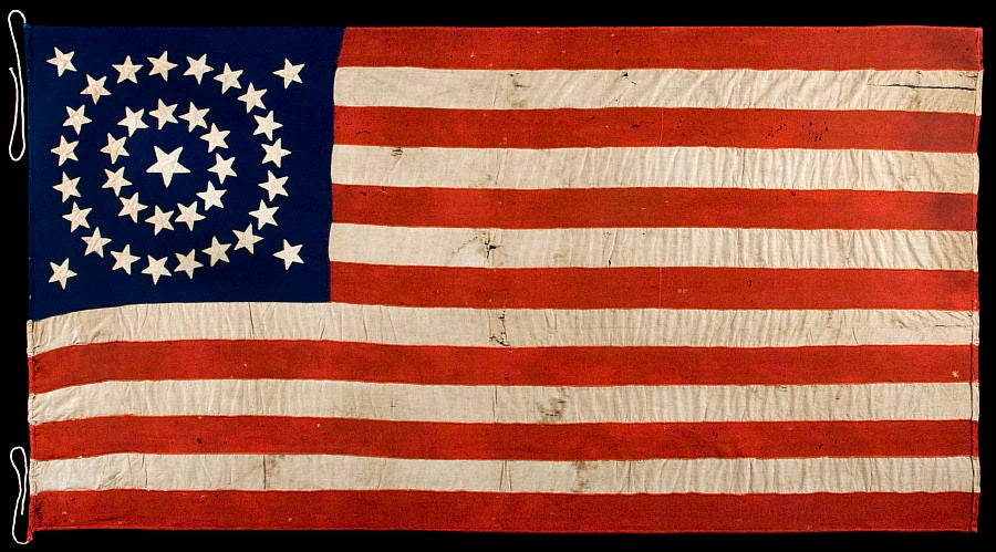 36 STARS IN A MEDALLION CONFIGURATION ON AN ENTIRELY HAND-SEWN FLAG WITH A BEAUTIFULLY ELONGATED FORMAT, CIVIL WAR ERA, 1864-67, NEVADA STATEHOOD:<br />
<br />
Entirely hand-sewn, 36 star American national flag with beautifully elongated