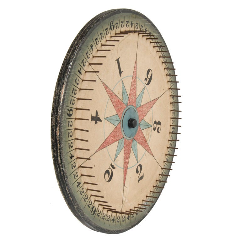 This impressively thick, two-sided game wheel is paint-decorated with overlaid red & sky blue stars. One side has 6-pointed stars with elongated arms and black lines extending so as to create a starburst effect that separates the wheel into 6 equal