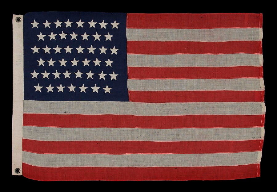 45 STARS ON THE SMALLEST PIECED-AND-SEWN, WOOL BUNTING, COMMERCIALLY MANUFACTURED FLAG THAT I HAVE EVER ENCOUNTERED, FLOWN AT AN INN IN OREGON DURING THE PATRIOTISM THAT SURROUNDED THE SPANISH-AMERICAN WAR, 1896-1908, UTAH STATEHOOD:<br />
<br