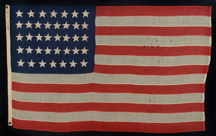 38 HAND-SEWN, SINGLE-APPLIQUÉD STARS ON A FLAG IN A VERY DESIRABLE SMALL SCALE FOR THE PERIOD, MADE BY ANNIN IN NEW YORK CITY, 1876-1889, COLORADO STATEHOOD:<br />
<br />
38 star American national flag in a desirable, small size for the period