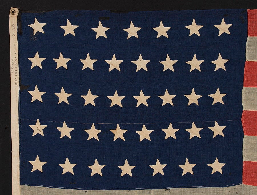38 star American national flag, by Annin in New York City. The flag is signed with a black stencil along the hoist binding that reads 