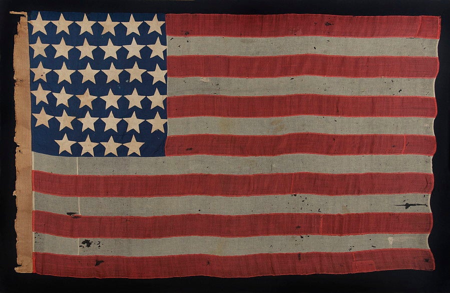 ENTIRELY HAND-SEWN 34 STAR FLAG OF THE CIVIL WAR PERIOD WITH A GREAT EARLY APPEARANCE, A WIDE LINEN SLEEVE, AND A VERY UNUSUAL ARRANGEMENT OF UNCOMMONLY LARGE STARS, 1861-63:

34 star American national flag, made in the opening years of the Civil