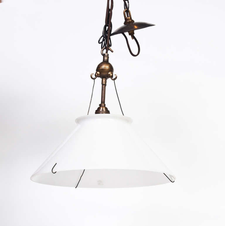 This unique milk glass pendant lamp is hung on a special hook and bar system that keeps the 	shade in place.
